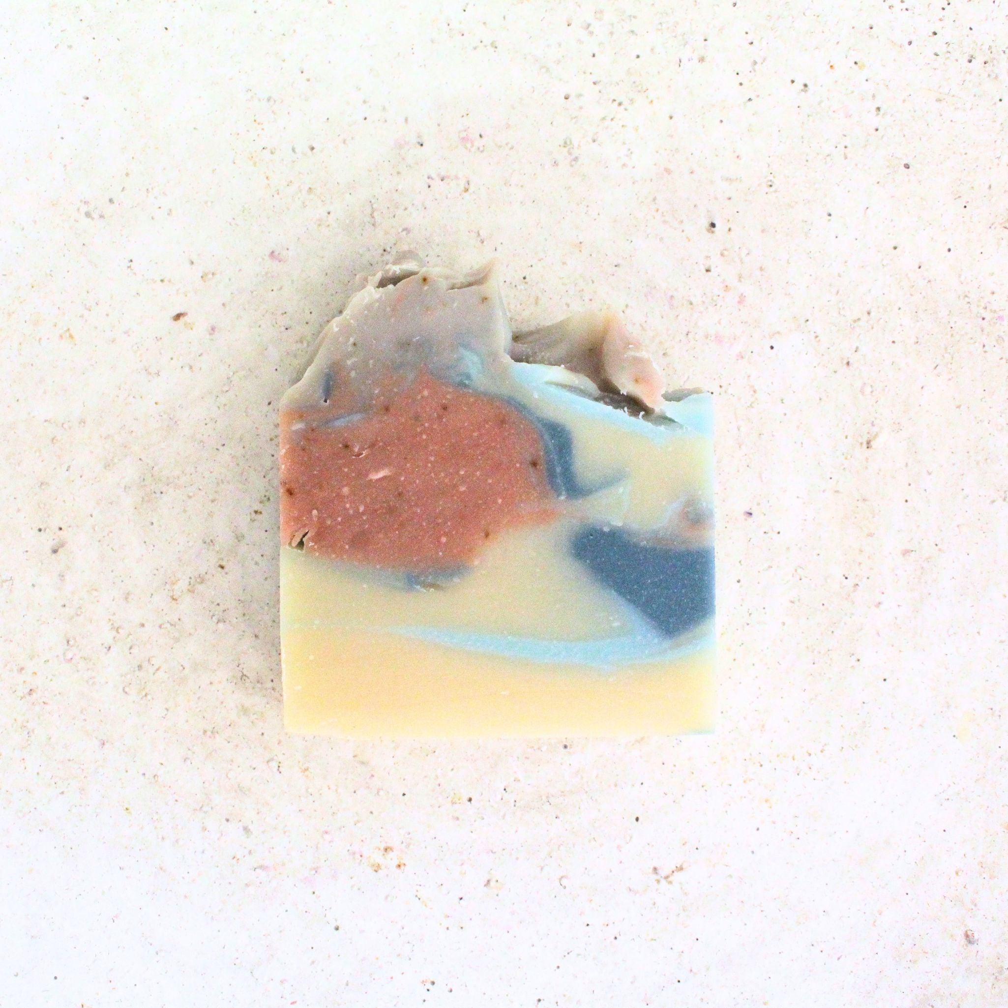 soap bar with swirled colors of pink blue and cream on white table