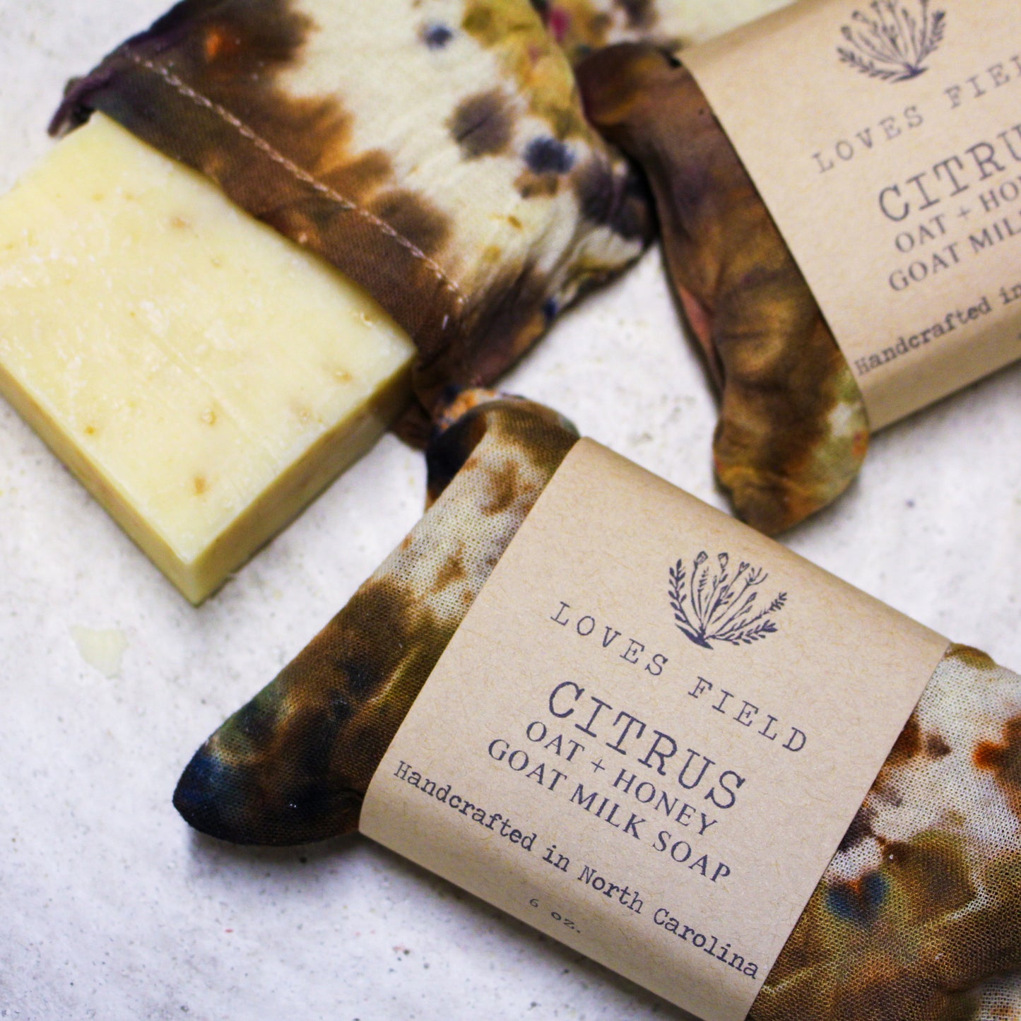 bar of citrus oatmeal soap on textured white surface