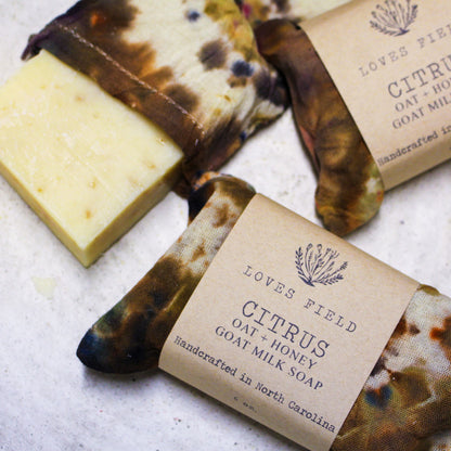 bar of citrus oatmeal soap on textured white surface