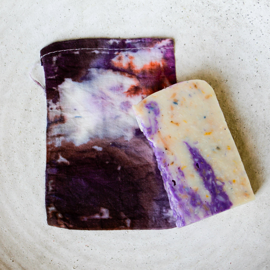 Two bars of soap with marbled patterns on a textured surface