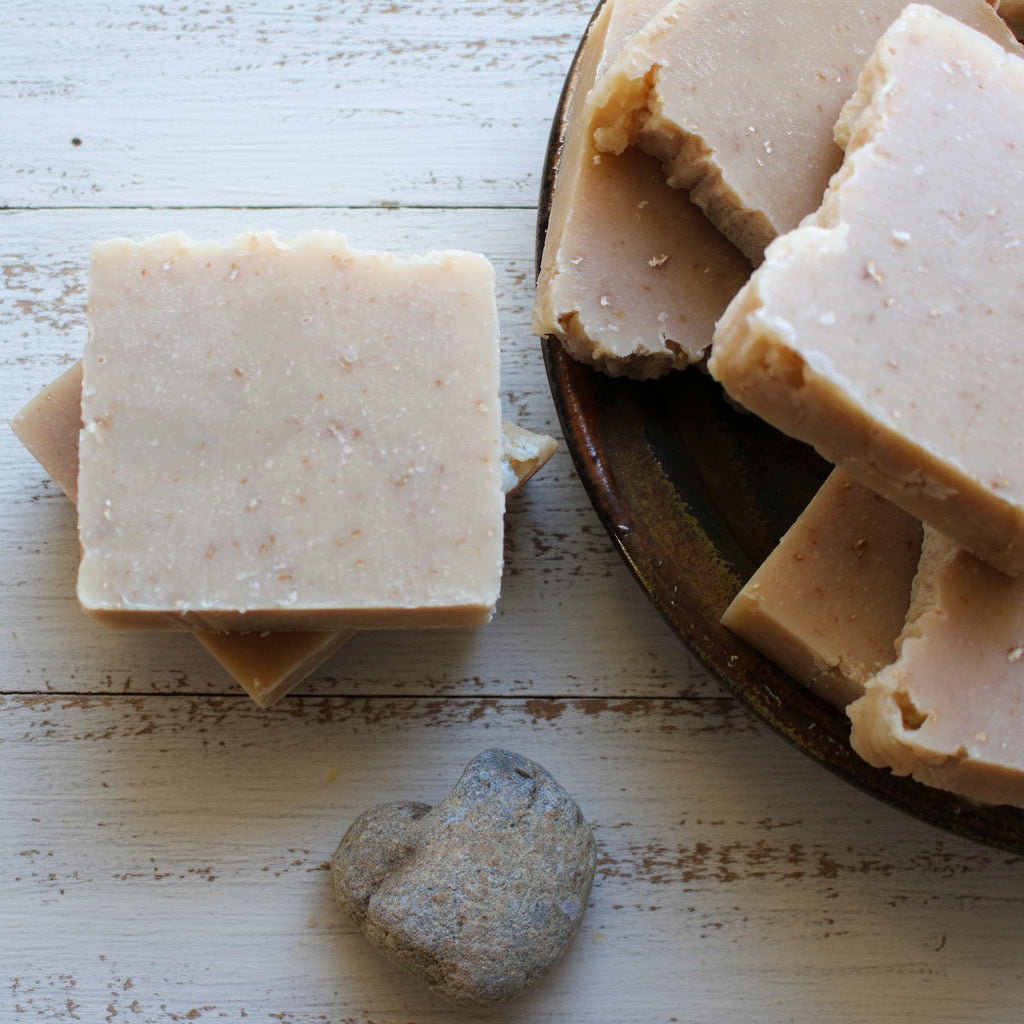 citrus oatmeal soap bar on a wooden surface with a rustic background