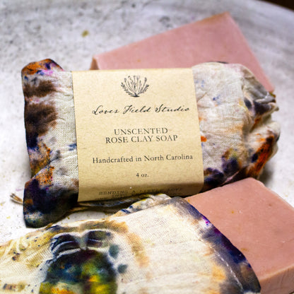 Unscented Rose Clay Soap with a tie-dye design and visible label on a textured surface.